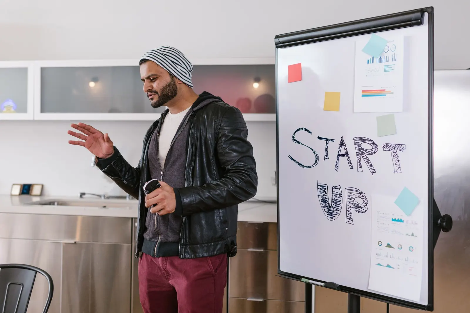 Presenter explaining a startup plan in front of a flip chart that reads Start Up